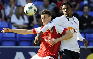 Arsenal's Laurent Koscielny (left) challenges Bolton Wanderers' Daniel Sturridge