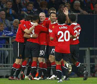 Manchester United players celebrate after a goal during their Champions League semi-final first leg match against Schalke 04 in Gelsenkirchen