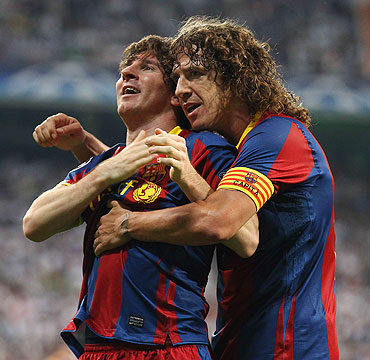 Barcelona's Lionel Messi celebrates with captain Carles Puyol