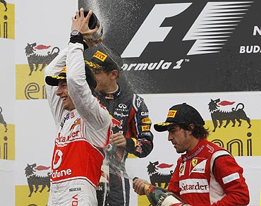 McLaren's Jenson Button (left), Red Bull's Sebastian Vettel (centre) and Ferrari's Fernando Alonso spray champagne on the podium