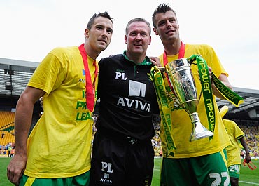 Manager of Norwich City Paul Lambert, Adam Drury and Elliot Ward celebrate the team's promotion to the EPL