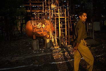 A police man looks on as he tours the site of the deserted Union Carbide factory that caused the ill-fated Bhopal Gas tragedy