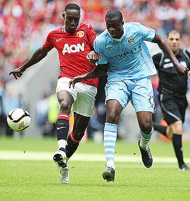 Danny Welbeck (left) and Yaya Toure of Manchester City battle for the ball during the FA Community Shield match on Sunday