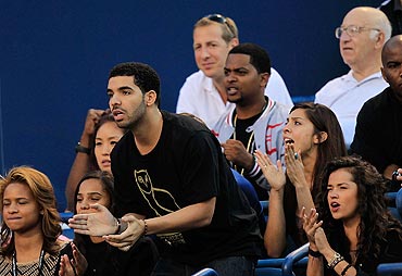 Canadian entertainer Drake applauds during the match between Serena Williams and Jie Zheng of China on Day 4 of the Toronto Cup on Thursday