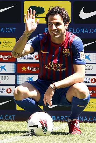Barcelona's new player Cesc Fabregas waves to photographers during his presentation at Nou Camp stadium