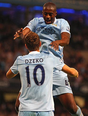 Manchester City's Edin Dzeko celebrates with teammate Yaya Toure after scoring the opening goal
