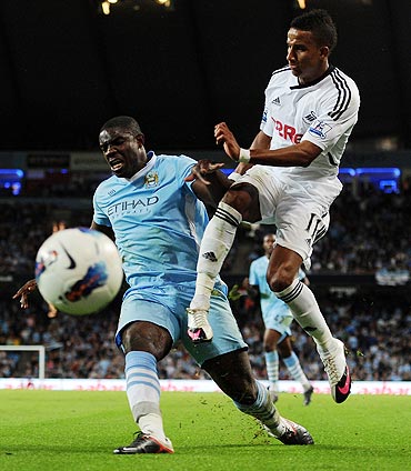 Manchester City's Micah Richards and Swansea City's Scott Sinclair vie for possession