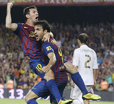 Barcelona's Lionel Messi (left) and Cesc Fabregas celebrate a goal against Real Madrid on Wednesday