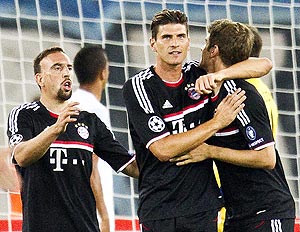 FC Bayern's Munich Mario Gomez celebrates with teammates Thomas Mueller (right) and Franck Ribery (left) after scoring against FC Zurich