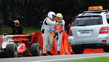 Lewis Hamilton of Great Britain and McLaren is helped into the medical car after crashing out during the Belgian Formula One Grand Prix