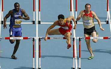 Liu Xiang of China clears a hurdle next to Willi Mathiszik of Germany and Ryan Brathwaite of Barbados in Daegu