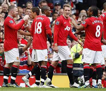 Manchester United players celebrate after scoring a goal against Arsenal