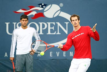 Andy Murray plays a forehand during a practice session as Daniel Vallverdu watches