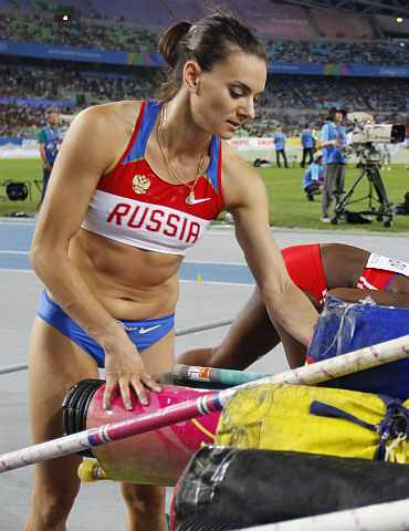 Yelena Isinbayeva packs her equipment after failing to progess in the women's pole vault final