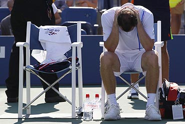 Conor Niland sits after retiring from the match against Novak Djokovic