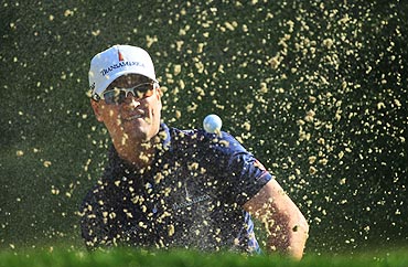 Zach Johnson plays a bunker shot on the 11th hole