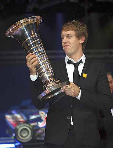 Formula One World Champion Sebastien Vettel of Germany holds his trophy during the 2010 FIA Prize Giving gala in Monaco
