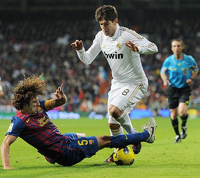 Carles Puyol (left) of FC Barcelona slides to stop Kaka of Real Madrid