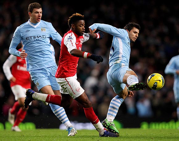 Arsenal's Alexandre Song challenges Manchester City's Sergio Aguero as they vie for possession