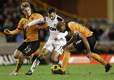Wolverhampton Wanderers' Kevin Doyle (left) and Karl Henry (right) challenge Manchester United's Ryan Giggs