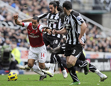 Arsenal's Theo Walcott (left) is challenged by Newcastle United's Jonas Gutierrez (2nd from left), Cheik Tiote (2nd from right) and Jose Enrique