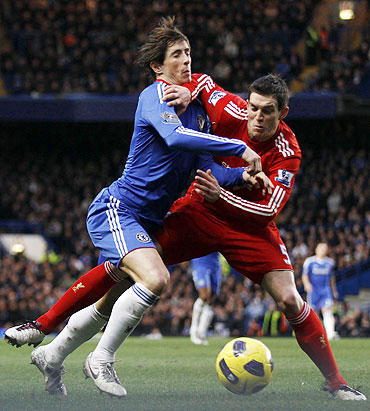 Chelsea's Fernando Torres (left) and Liverpool's Daniel Agger get involved in a fierce challenge