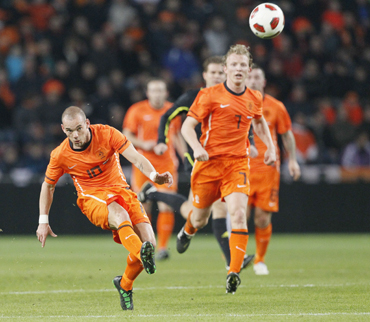 Wesley Sneijder of the Netherlands (L) shoots the ball, while teammate Dirk Kuyt watches, during their international friendly soccer match against Austria in Eindhoven