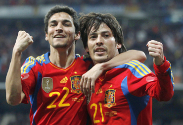 Spain's David Silva (R) celebrates with team mate Jesus Navas after scoring a goal against Colombia