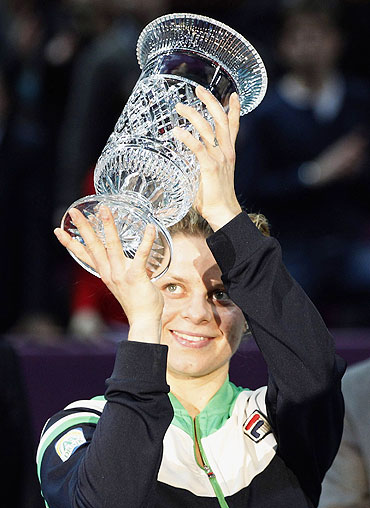 Kim Clijsters celebrates with the trophy after being declared WTA world number one after her Paris Open semi-final win against Jelena Dokic on Friday