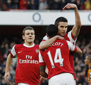 Arsenal's Robin Van Persie gestures as teammate Arsenal's Theo Walcott (14) congratulates him after scoring their second goal