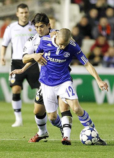 Schalke 04's Peer Kluge (front) is challenged by Valencia's Ever Banega on Tuesday
