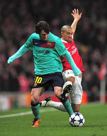 Arsenal's Gael Clichy challenges Barcelona's Lionel Messi during their Champions League match at the Emirates Stadium