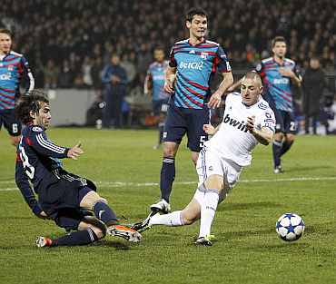 Real Madrid's Karim Benzema (C) shoots to score against Olympique Lyon during their Champions League match at Gerland stadium