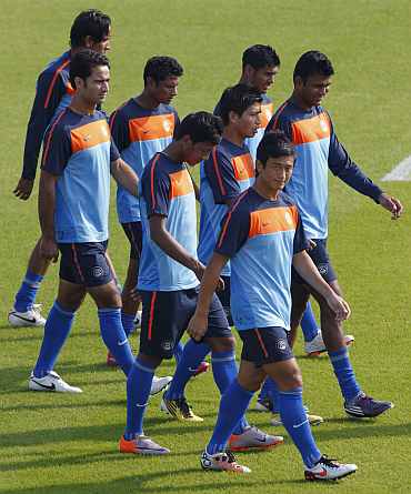 Indian players warm up during a practice session at Al Wakrah Stadium in Doha
