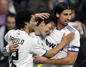 Real Madrid's Mesut Ozil (centre) is congratulated by team-mates Marcelo (left) and Sami Khedira after scoring the winner during their Spanish King's Cup quarter-final first leg against Atletico Madrid