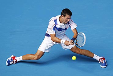 Novak Djokovic slides as he returns against compatriot Viktor Troicki on Friday