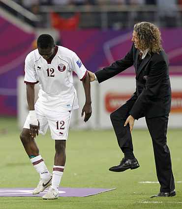 Qatar's coach Bruno Metsu speaks to his player Yusef Ahmed during a match
