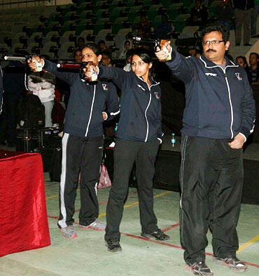 Samresh Jung (right), Heena Sidhu (centre) and Annu Raj Singh shoot at targets to reveal the logo