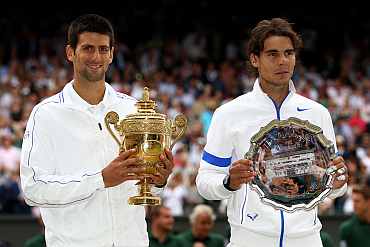 Winner Novak Djokovic (L) and runner-up Rafael Nadal with their trophies after their final round of the Wimbledon
