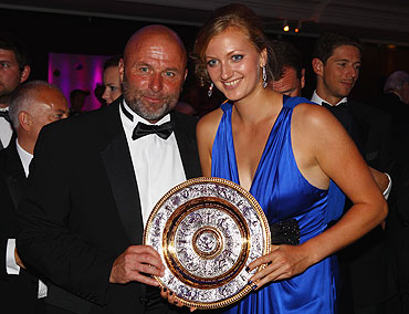 Petra Kvitova holds the replica of the womens trophy as she poses with her coach David Kotyza at the Wimbledon Championships 2011 Winners Ball on Sunday