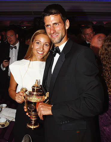 Novak Djokovic and girlfriend Jelena Ristic pose with the replica of the mens trophy at the Winners Ball on Sunday