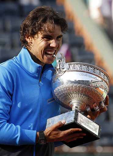 Rafa Nadal poses with the trophy after defeating Federer during their men's final at the French Open