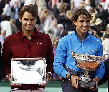 Rafa Nadal and Roger Federer pose with their trophies after their men's final at the French Open