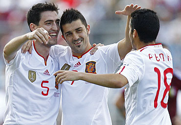 Spain's David Villa (centre) celebrates with teammates Andoni Iraola (left) and Pedro Rodriguez after scoring against Venezuela