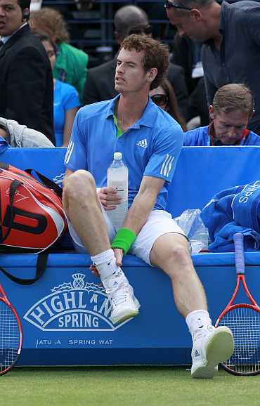 Andy Murray touches his ankle during a break in the match against Xavier Malisse of Belgium at the Queen's Club Championships