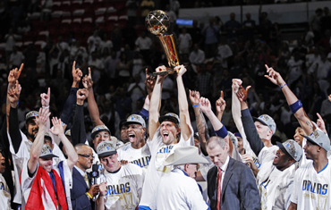 Dallas Mavericks' Dirk Nowitzki lifts the Larry O'Brien Championship Trophy with his teammates after they beat the Miami Heat in Game 6 to win the NBA Finals basketball series in Miami