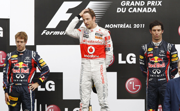 McLaren driver Jenson Button of Britain (C), Red Bull driver Sebastian Vettel (L) and third place Mark Webber stand on the podium