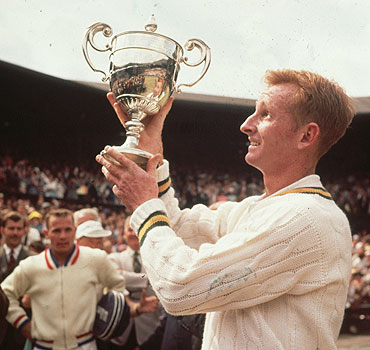 Rod Laver of Australia lifts the men's singles trophy after beating Chuck McKinley of the United States in 1961