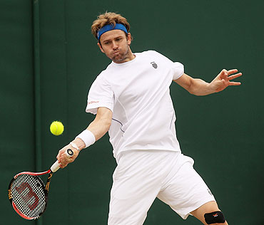 Mardy Fish returns a shot against Robin Haase