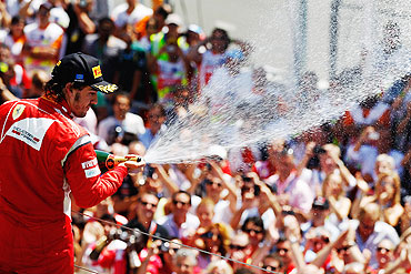 Ferrari's Fernando Alonso celebrates on the podium after finishing second during the European Formula One Grand Prix